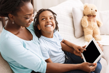 African-american mom and daughter using digital tablet
