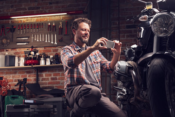 Man taking photo of motorcycle in garage