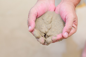 Sea sand in hand of people