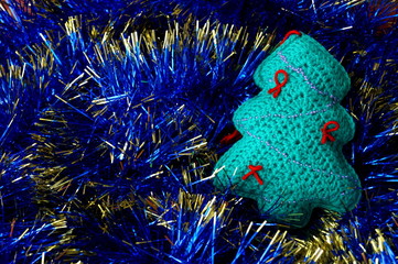 Crochet Christmas tree on a background of tinsel