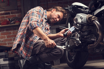 Obraz na płótnie Canvas Mechanic working on repairing a vintage motorcycle