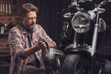 Mechanic working on a vintage motorcycle - 302270017