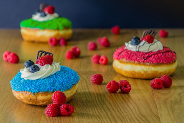 delicious donuts with raspberries on wooden table