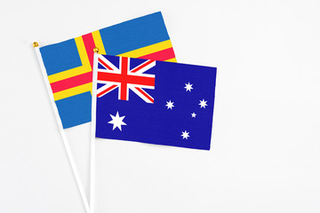 Australia and Aland Islands stick flags on white background. High quality fabric, miniature national flag. Peaceful global concept.White floor for copy space.