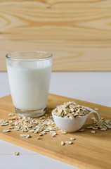 oatmeal and a glass of oat milk on a wooden background