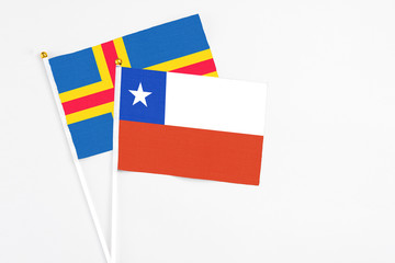 Chile and Aland Islands stick flags on white background. High quality fabric, miniature national flag. Peaceful global concept.White floor for copy space.