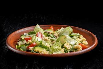 Green salad with couscous, avocado and tomato.