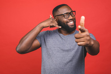 Young african american man wearing casual t-shirt standing over isolated red background smiling...