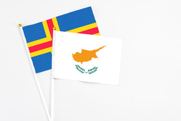 Cyprus and Aland Islands stick flags on white background. High quality fabric, miniature national flag. Peaceful global concept.White floor for copy space.