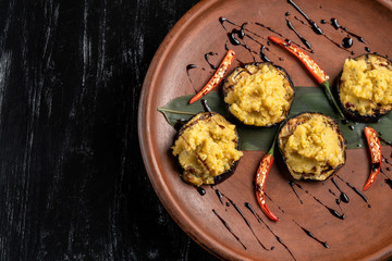 Pumpkin puree is laid out on grilled eggplant.