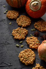 Healthy vegan gluten free food. Homemade pumpkin oatmeal breakfast cookies with seeds and turban squash on black background