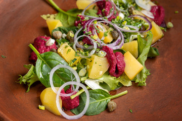 Boiled potatoes with dill and beetroot paste. Sprinkled with onions and capers.