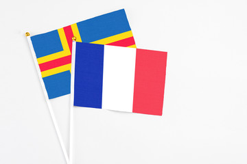 France and Aland Islands stick flags on white background. High quality fabric, miniature national flag. Peaceful global concept.White floor for copy space.