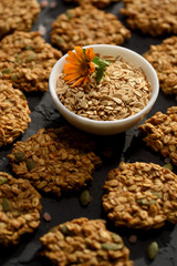 Healthy vegan food. Homemade pumpkin oatmeal breakfast cookies and oats on black background