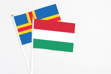 Hungary and Aland Islands stick flags on white background. High quality fabric, miniature national flag. Peaceful global concept.White floor for copy space.