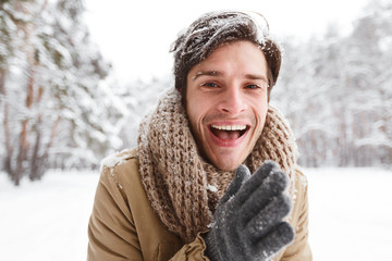 Guy Rubbing Hands To Warm Up Standing In Winter Forest