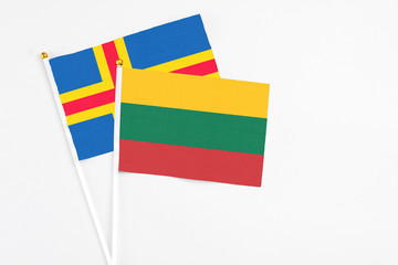 Lithuania and Aland Islands stick flags on white background. High quality fabric, miniature national flag. Peaceful global concept.White floor for copy space.