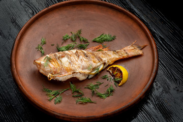 Grilled sea bass on a beautiful clay plate.