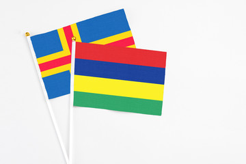 Mauritius and Aland Islands stick flags on white background. High quality fabric, miniature national flag. Peaceful global concept.White floor for copy space.