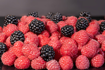Ripe and fresh raspberries and blackberry, sweet dark blackberry over red raspberries, berries food