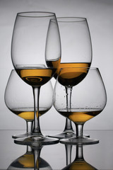 Wine glass goblets on long legs. Nearby are glasses on a short leg. They have a small amount of alcohol.