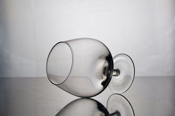 Short-stemmed wine glass. Lies on its side, photographed in the light.