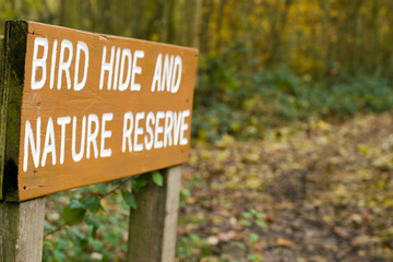 Sign pointing way to bird hide and nature reserve