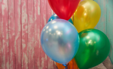 background of multicolored balloons and a beautiful wooden wall in pink and blue