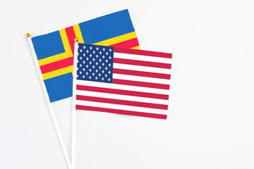 United States and Aland Islands stick flags on white background. High quality fabric, miniature national flag. Peaceful global concept.White floor for copy space.