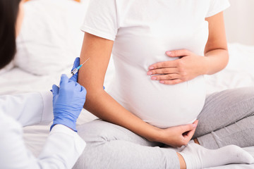 Unrecognizable Pregnant Lady Receiving Injection Sitting On Bed, Cropped