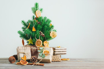 Dried citrus slices on the Christmas tree with craft paper wrapping gift boxes