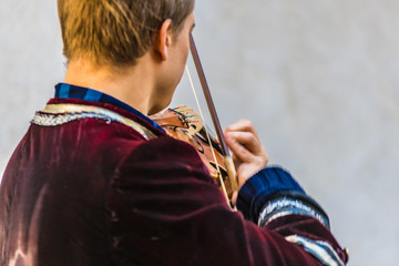backview of a violine player making street music in historic costume - 302281478
