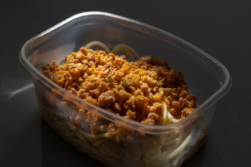 Pasta with minced meat and onion in navy-style on a gray background.