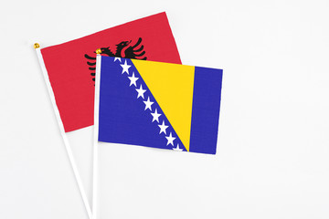 Bosnia Herzegovina and Albania stick flags on white background. High quality fabric, miniature national flag. Peaceful global concept.White floor for copy space.