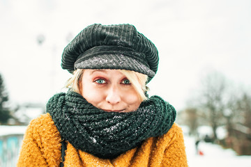 Portrait of cute blond girl in winter clothing, freezing outside. Winter time