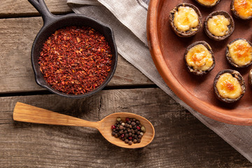 Roasted mushrooms under melting cheese spices on fabric background, top view