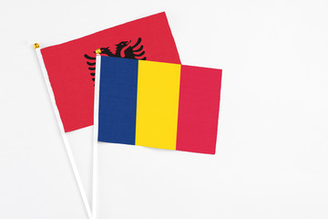 Chad and Albania stick flags on white background. High quality fabric, miniature national flag. Peaceful global concept.White floor for copy space.