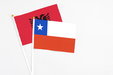 Chile and Albania stick flags on white background. High quality fabric, miniature national flag. Peaceful global concept.White floor for copy space.