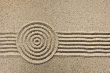 Fototapeta na wymiar Simple spiritual patterns in a Japanese Zen Garden with concentric circles and parallel lines raked in sand