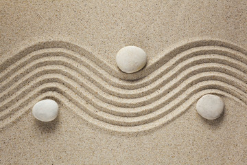 Fototapeta na wymiar zen garden stones in light sand for relaxation and concentration during meditation