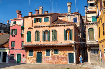 Fototapeta na wymiar Venice, Italy. Old house with chimneys and green shutters