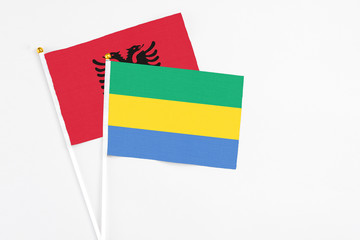 Gabon and Albania stick flags on white background. High quality fabric, miniature national flag....