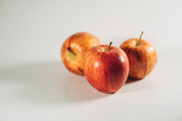 three red apples on white background