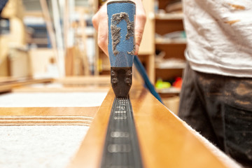 shipwright using a pneumatic staple gun to fix velcro strap