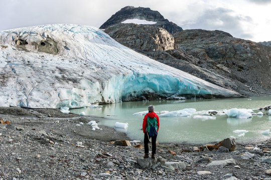 Rear view of hiker against melting glacier