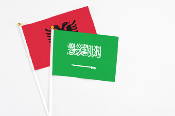 Saudi Arabia and Albania stick flags on white background. High quality fabric, miniature national flag. Peaceful global concept.White floor for copy space.
