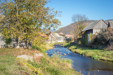 Beautiful landscape image of a small village along a stream in Transylvania, Romania