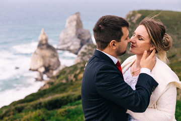 newlyweds closed their eyes and want to kiss on the coast of sea