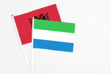Sierra Leone and Albania stick flags on white background. High quality fabric, miniature national flag. Peaceful global concept.White floor for copy space.