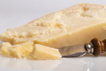 Trancio e scaglie di formaggio su sfondo bianco